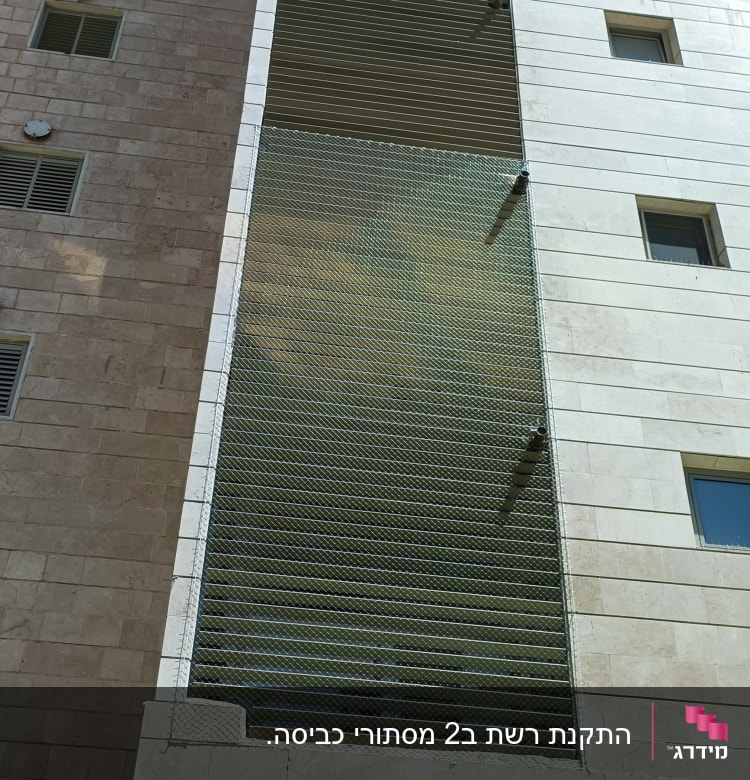 רשת מתכת מותקנת על חזית בניין למניעת יונים